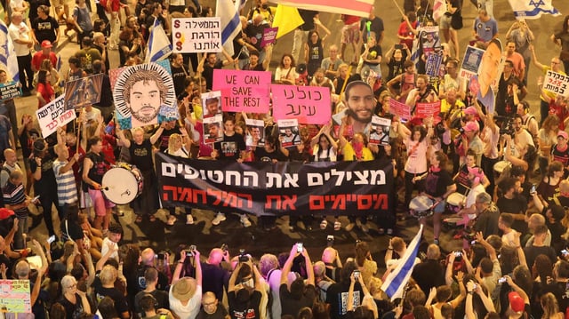 Teilnehmer einer Anti-Regierungsdemonstration in Tel Aviv, Israel, halten Plakate mit Bildern von entführten Israelis in die Höhe