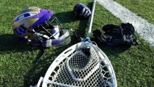 Lacrosse equipment on the sideline of a field.