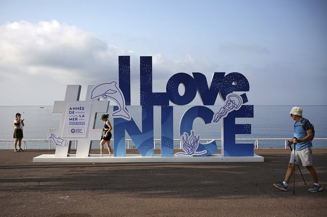 People walk on the sea promenade ahead of the UN Ocean Conference, Saturday, June 7, 2025 in Nice, French Riviera. (AP Photo/Laurent Cipriani)
