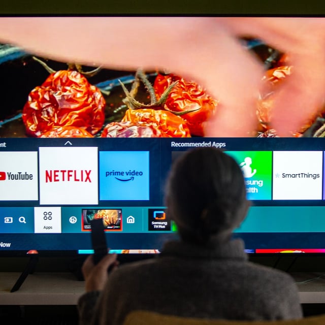 A person browses a television menu showing icons for streaming services Netflix and Amazon Prime in a photo illustration made in Toronto on Friday, March 22, 2024. THE CANADIAN PRESS/Giordano Ciampini