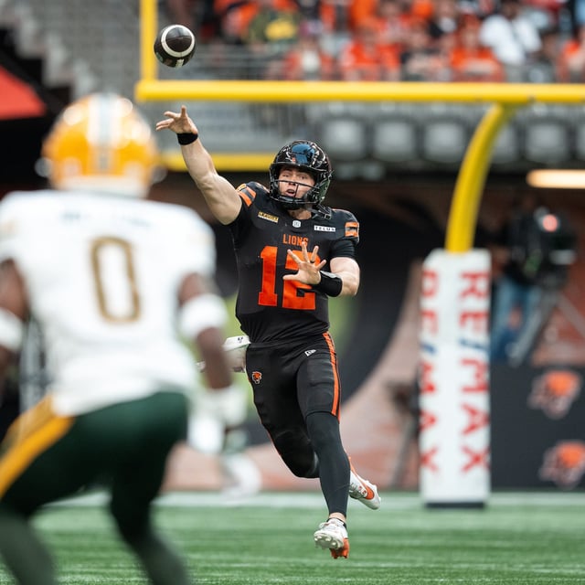 B.C. Lions quarterback Nathan Rourke (12) throws the ball as Edmonton Elks' Kobe Williams (0) watches during the first half of a CFL football game in Vancouver, on Saturday, June 7, 2025. THE CANADIAN PRESS/Ethan Cairns