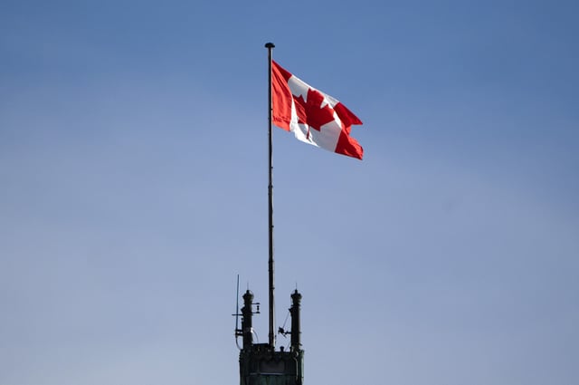 The Canadian flag flies over the Peace Tower on Parliament Hill, Friday, Feb. 14, 2025 in Ottawa.  THE CANADIAN PRESS/Adrian Wyld