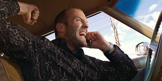 Chev Chelios, played by Jason Statham, shouts into a phone while sitting in a car in 'Crank'.