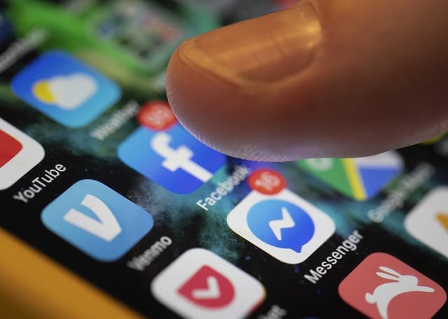 FILE - A smartphone displays the apps for Facebook and Messenger in New Orleans, Aug. 11, 2019.