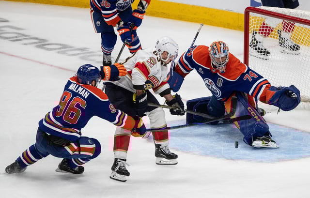 Florida Panthers' Brad Marchand (63) is stopped by Edmonton Oilers goalie Stuart Skinner (74) as Jake Walman (96) defends during the first overtime period in Game 2 of the NHL Stanley Cup final in Edmonton, Friday, June 6, 2025.