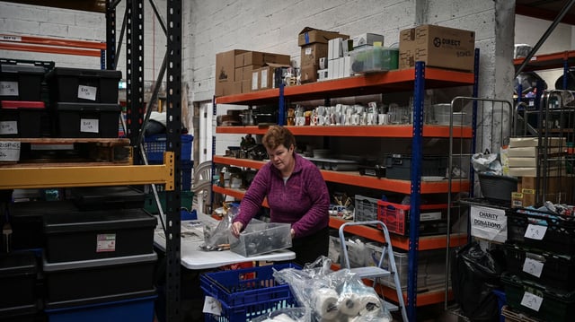 A volunteer at a food bank packaging supplies. Credit: IFAN Mary Turner The Welcome Centre