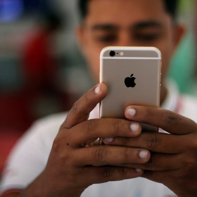 FILE PHOTO: A salesman checks a customer's iPhone at a mobile phone store in New Delhi, India, July 27, 2016. REUTERS/Adnan Abidi/File Photo