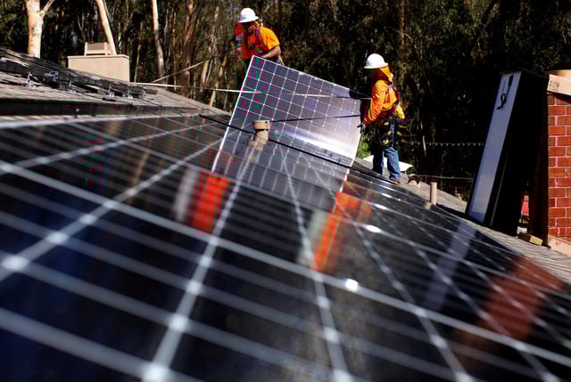 Solar installers from Baker Electric place solar panels on the roof of a residential home in Scripps Ranch, San Diego, California, U.S. October 14, 2016. Picture taken October 14, 2016.       REUTERS/Mike Blake/File Photo