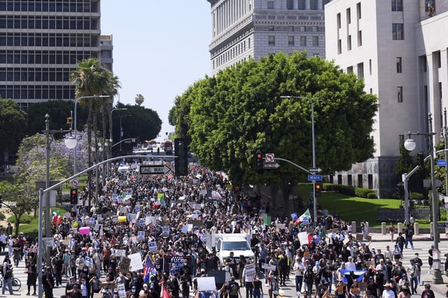 EDS NOTE: OBSCENITY - Protesters march from City Hall to the Metropolitan Detention Center in downtown Los Angeles, Sunday, June 8, 2025, following last night's immigration raid protest. (AP Photo/Jae Hong)