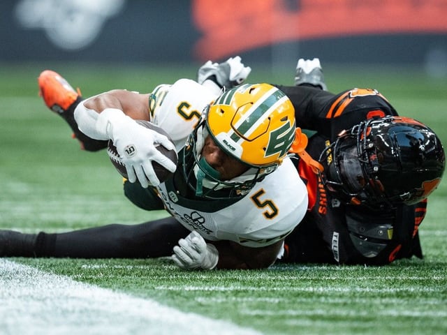 Edmonton Elks' Justin Rankin is tackled by B.C. Lions' Deontai Williams during CFL game in Vancouver June 7, 2025. 