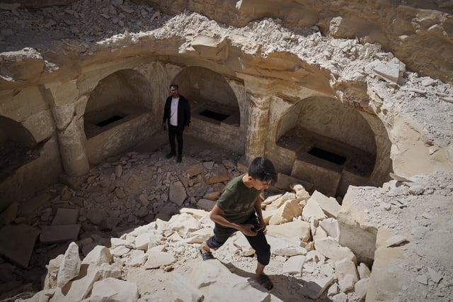 A boy walks out of a pit after exploring the tombs from a Byzantine underground complex, believed to be over 1,500 years old, uncovered by a contractor during the reconstruction of a war-damaged house in Maarat al-Numan, Idlib suburb, Syria, Friday, May 30, 2025. (AP Photo/Omar Albam)