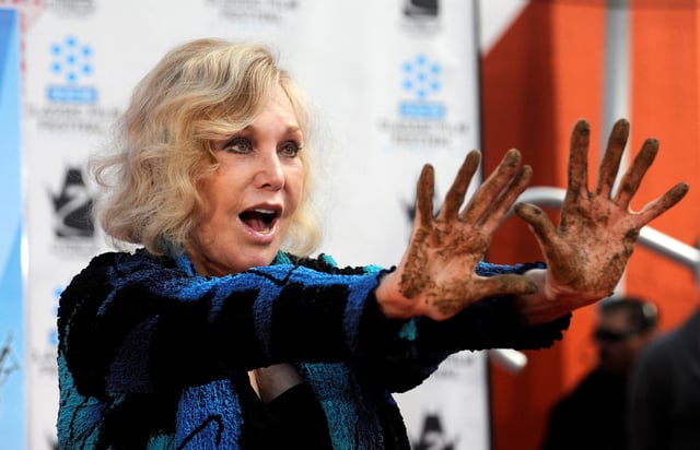 Kim Novak poses for photographers at a ceremony after she placed hand and footprints in cement in the forecourt of Grauman's Chinese Theatre in Hollywood, Los Angeles April 14, 2012. REUTERS/Phil McCarten/File Photo