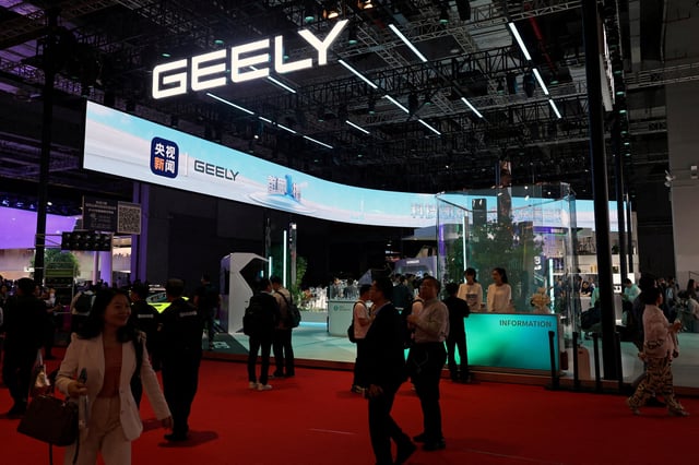 People walk past the Geely booth during a media day for the Auto Shanghai show in Shanghai, China April 23, 2025. REUTERS/Go Nakamura/File Photo