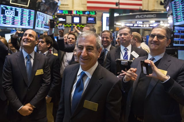 Chief executive officer of Moelis & Co., Ken Moelis (C), smiles after ringing the bell to mark the company's IPO on the floor of the New York Stock Exchange shortly after the opening bell in New York April 16, 2014. REUTERS/Lucas Jackson/ File Photo