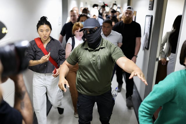 An ICE agent in a mask leads the way as a man is detained after his immigration court hearing in New York on June 6, 2025. 