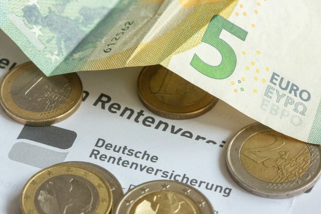 Münzen und eine Banknote liegen auf einer Renteninformation der Deutschen Rentenversicherung