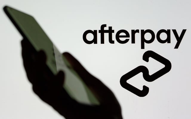 A smartphone is held in front of a displayed Afterpay logo in this illustration taken, August 2, 2021. REUTERS/Dado Ruvic/Illustration/ File Photo