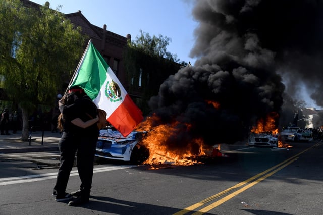 Several Waymo cars burn on Los Angeles Street as protests against federal anti immigration efforts have escalated with the arrival of California’s National Guard near the Metropolitan Detention Center in Los 
Angeles on Sunday, June 8, 2025. (Photo by Axel Koester, Contributing Photographer)