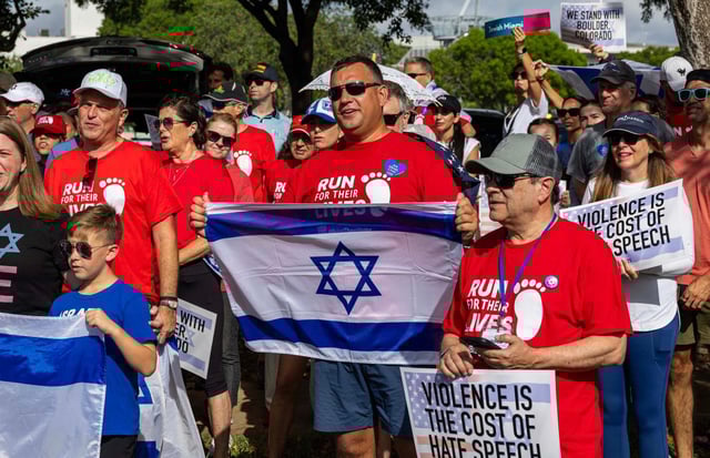Demonstrators hold Israeli flags and signs that read “HATE IS NOT AN AMERICAN VALUE” during a solidarity “Run for Their Lives” walk to raise awareness for the 58 hostages still held in Gaza at Aventura Circle on Sunday, June 8, 2025, in Aventura, Fla. (D.A. Varela/Miami Herald/TNS/Courtesy)