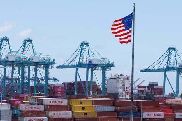 An American flag flutters over a ship and shipping containers at the Port of Los Angeles, in San Pedro California, U.S., May 13, 2025. REUTERS/Mike Blake/ File Photo