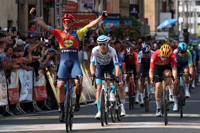 Jonathan Milan lève les bras à l'arrivée de la 2e étape du Critérium du Dauphiné, le 9 juin 2025 à Issoire. Un temps lâché, le sprinteur italien de Lidl-Trek, aidé par ses coéquipiers, a pu réintégrer le peloton