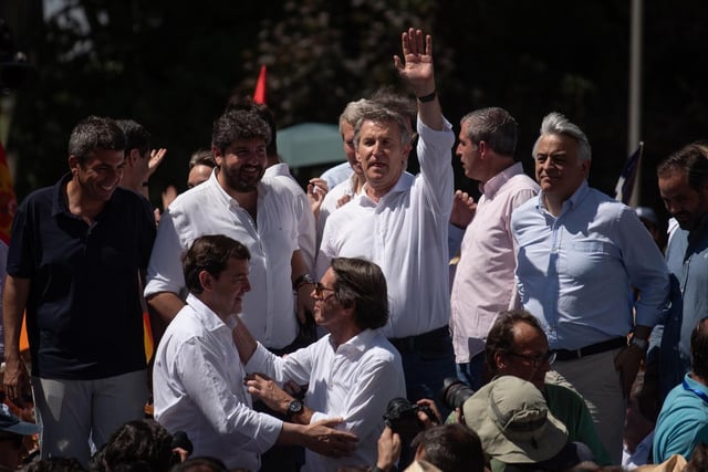 Mazón, en una esquina del escenario, tras la manifestación de este domingo en Madrid contra el Gobierno.
