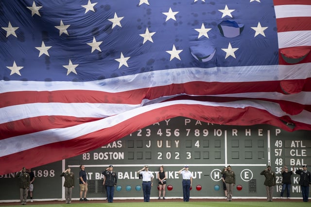 An American flag is draped over the Green Monster for Independence Day before a game between the Texas Rangers and the Boston Red Sox on July 4, 2023 at Fenway Park in Boston, Massachusetts.