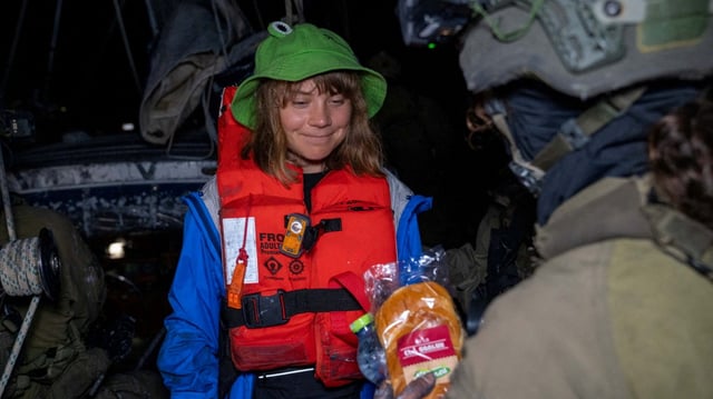 An Israeli solider passes a bun to Greta Thunberg onboard the Gaza-bound British-flagged yacht "Madleen" after Israeli forces boarded the charity vessel as it attempted to reach the Gaza Strip in defiance of an Israeli naval blockade, in this still image released on June 9, 2025.