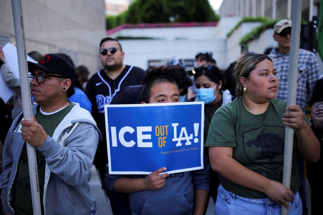 A protester holds a placard as they gather around the Los Angeles Federal Building following multiple detentions by Immigration and Customs Enforcement (ICE), in downtown Los Angeles, California, U.S., June 6, 2025. REUTERS/Daniel Cole/File Photo