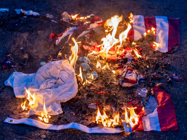 A burnt US flag is seen on the ground amid clashes with law enforcement in the streets surrounding the federal building during a protest following federal immigration operations in Los Angeles, California, on June 8, 2025. Demonstrators torched cars and scuffled with security forces in Los Angeles on June 8, as police kept protestors away from the National Guard troops President Donald Trump sent to the streets of the second biggest US city. (RINGO CHIU/AFP via Getty)