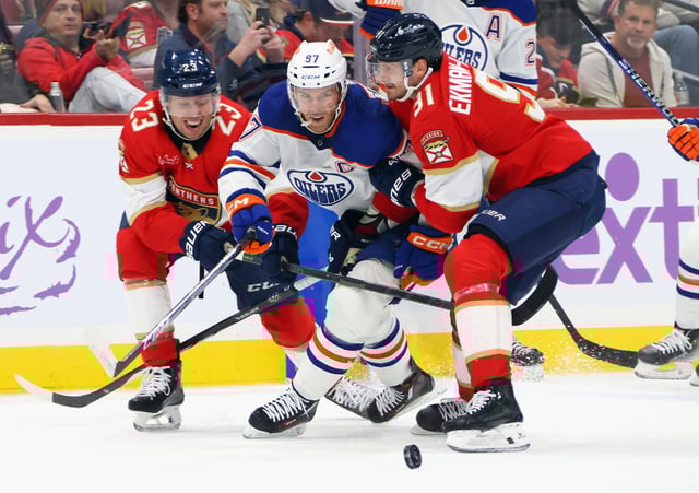 Carter Verhaeghe #23 and Aaron Ekblad #5 of the Florida Panthers defend against Connor McDavid #97 of the Edmonton Oilers during the first period at Amerant Bank Arena on November 20, 2023 in Sunrise, Florida.