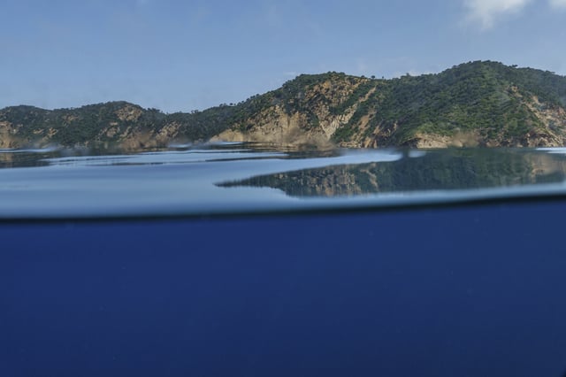 Mountains are reflected in the waters of France's Port-Cros National Park ahead of the U.N. Ocean Conference, Saturday, June 7, 2025, (AP Photo/Annika Hammerschlag)