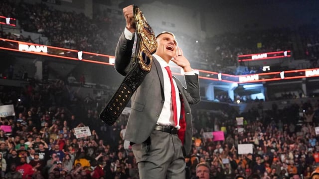Gunther stands on the announce table while holding the World Heavyweight Championship on “WWE Raw.” (via WWE)