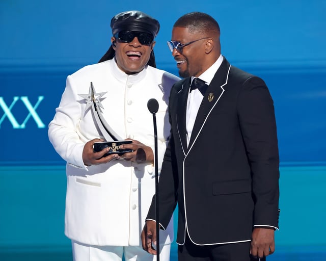 (L-R) Stevie Wonder presents Jamie Foxx with the Ultimate Icon Award onstage.