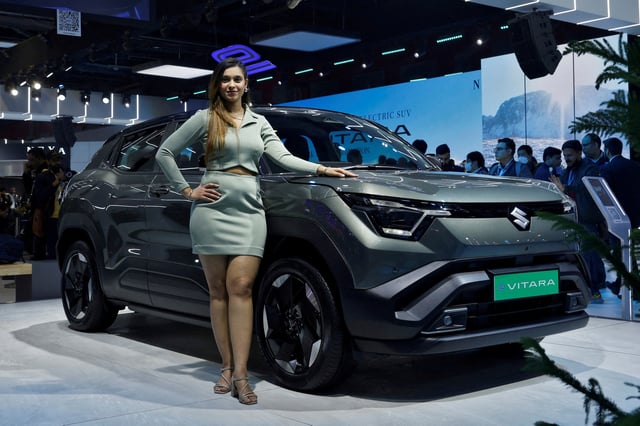 A model poses next to Maruti Suzuki's first EV, the e Vitara SUV on display at India's five-day auto show in New Delhi, India, January 17, 2025. REUTERS/Priyanshu Singh/File Photo