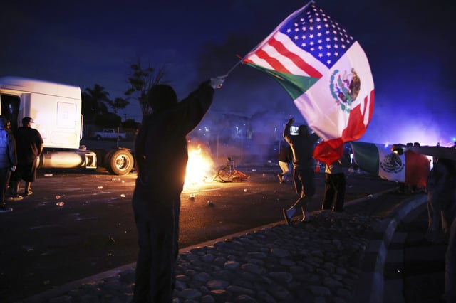 A demonstrator waves an American and Mexican flag during a protest in Compton, Calif., Saturday, June 7, 2025, after federal immigration authorities conducted operations.
