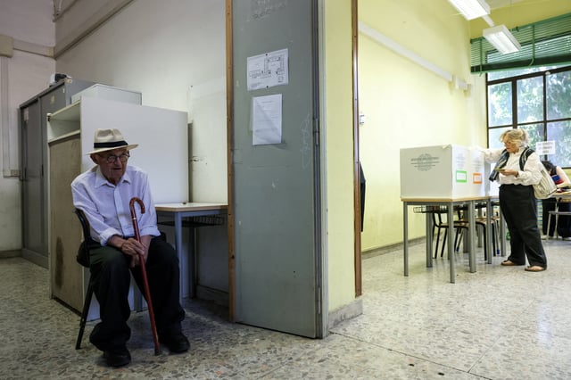 A person sits at a polling station, during a referendum on employment and Italian citizenship at a polling station in Rome, Italy, June 8, 2025. REUTERS/Matteo Minnella/File Photo