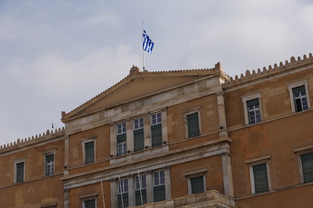 A Greek flag flutters atop the parliament building in Athens, Greece, March 1, 2023. REUTERS/Louiza Vradi/ File Photo