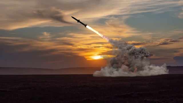 Rocket launch against the background of the evening field, the setting sun. stock photo