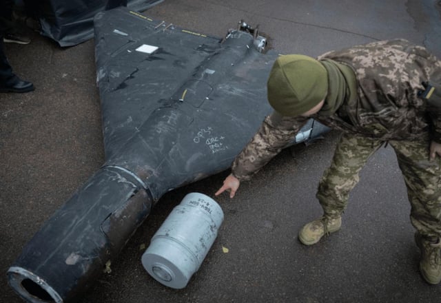 A Ukrainian officer shows a thermobaric charge of a downed Shahed drone launched by Russia in a research laboratory in an undisclosed location in Ukraine on Thursday, Nov. 14, 2024.
