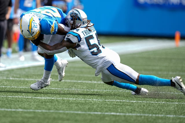 Sep 15, 2024; Charlotte, North Carolina, USA; Los Angeles Chargers running back J.K. Dobbins (27) is tackled by Carolina Panthers linebacker Shaq Thompson (54) during the second half at Bank of America Stadium. Mandatory Credit: Jim Dedmon-Imagn Images/File Photo