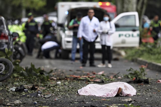 A body lies in the street, covered by a sheet, after a bomb explosion in Cali, Colombia, Tuesday, June 10, 2025. (AP Photo/Santiago Saldarriaga)