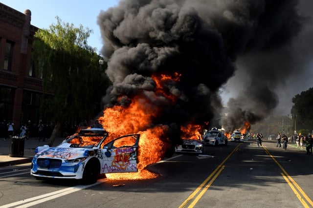 Several Waymo cars burn on Los Angeles Street as protests against federal anti immigration efforts have escalated with the arrival of California’s National Guard near the Metropolitan Detention Center in Los 
Angeles on Sunday, June 8, 2025. (Photo by Axel Koester, Contributing Photographer)