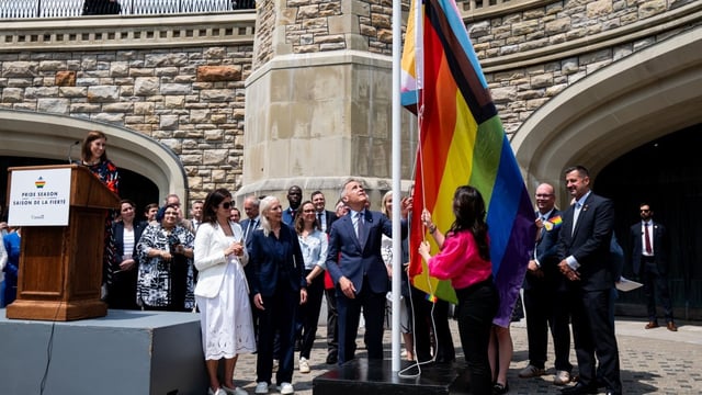 Prime Minister Mark Carney, centre-left, takes part in a flag-raising ceremony with Minister of Women and Gender Equality Rechie Valdez marking Pride Month on Parliament Hill. Carney announced $1.5 million in funding to help keep Pride parades safe.