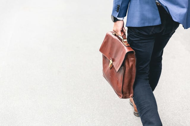 person with briefcase walking away