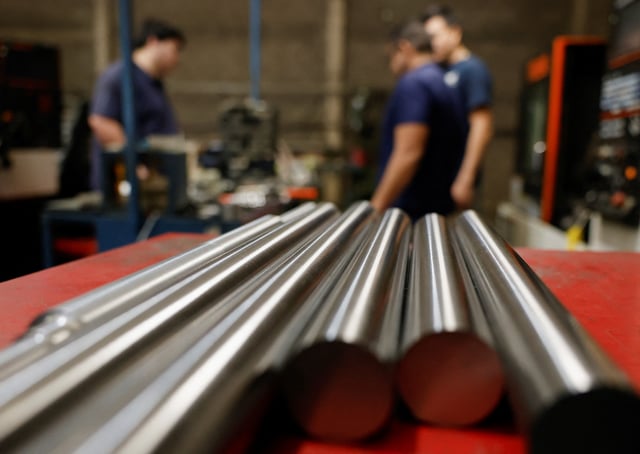 Workers stand near steel bars at a metal-mechanical parts factory with application to industry, in Apodaca, Mexico, March 11, 2025. REUTERS/Daniel Becerril/File photo