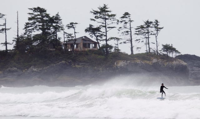 A surfer rides a wave on Chesterman Beach in Tofino, B.C., Tuesday, April, 17, 2012. THE CANADIAN PRESS/Jonathan Hayward