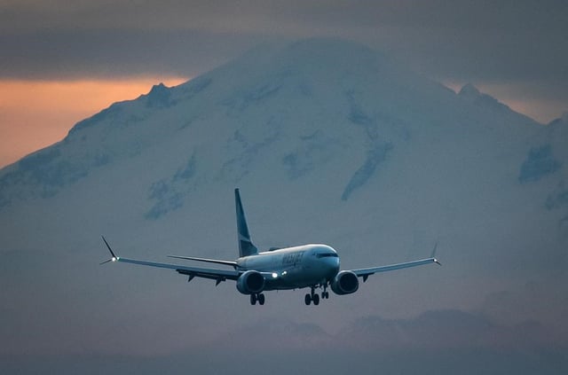 Mount Baker in Washington is seen in the distance as a WestJet Airlines Boeing 737 Max aircraft arrives at Vancouver International Airport in Richmond, B.C., on Jan. 21, 2021. 
