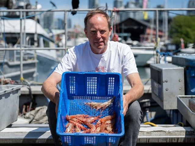 Stewart McDonald, Owner of Salty Stew's Seafood, holds a basket of spot prawns on his boat at False Creek Harbour Authority, Fishermen's Wharf in Vancouver, on Thursday, June 5, 2025.