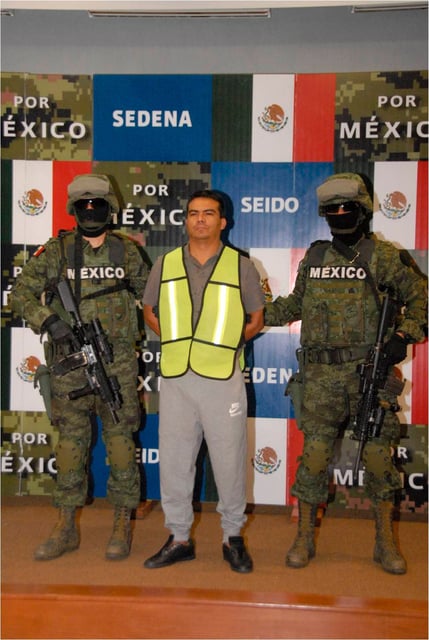 Mexican soldiers escort Jesus Alfredo Salazar Ramirez (C), a top member of the Sinaloa cartel, in this undated handout picture distributed by the Mexican Defense Ministry and received by Reuters on Nov. 4, 2012.
